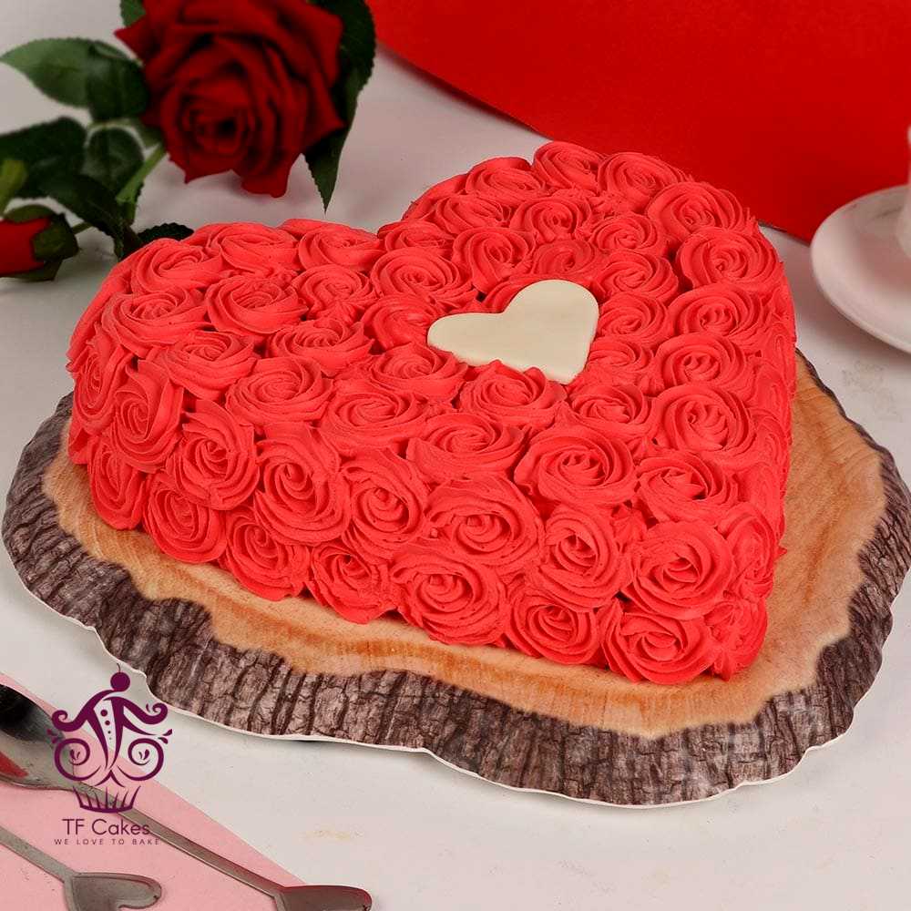A Heart Shaped Cake Decorated With Buttercream Roses In Amber Pink Topped  With Cute Pearls - CakeCentral.com